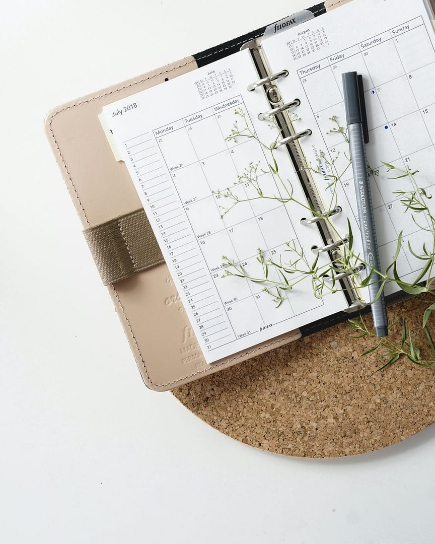 grey and black pen on calendar book